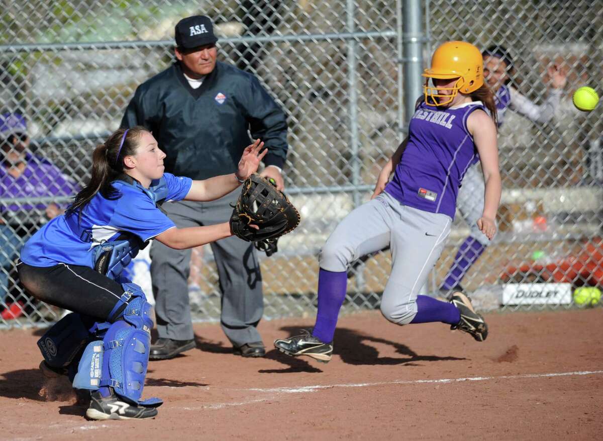 Darien's Olivia Gozdz reaches for the ball as Westhill's Tammy Wise slides into the plate during Friday's softball game at Westhill High School in Stamford on April 13, 2012.