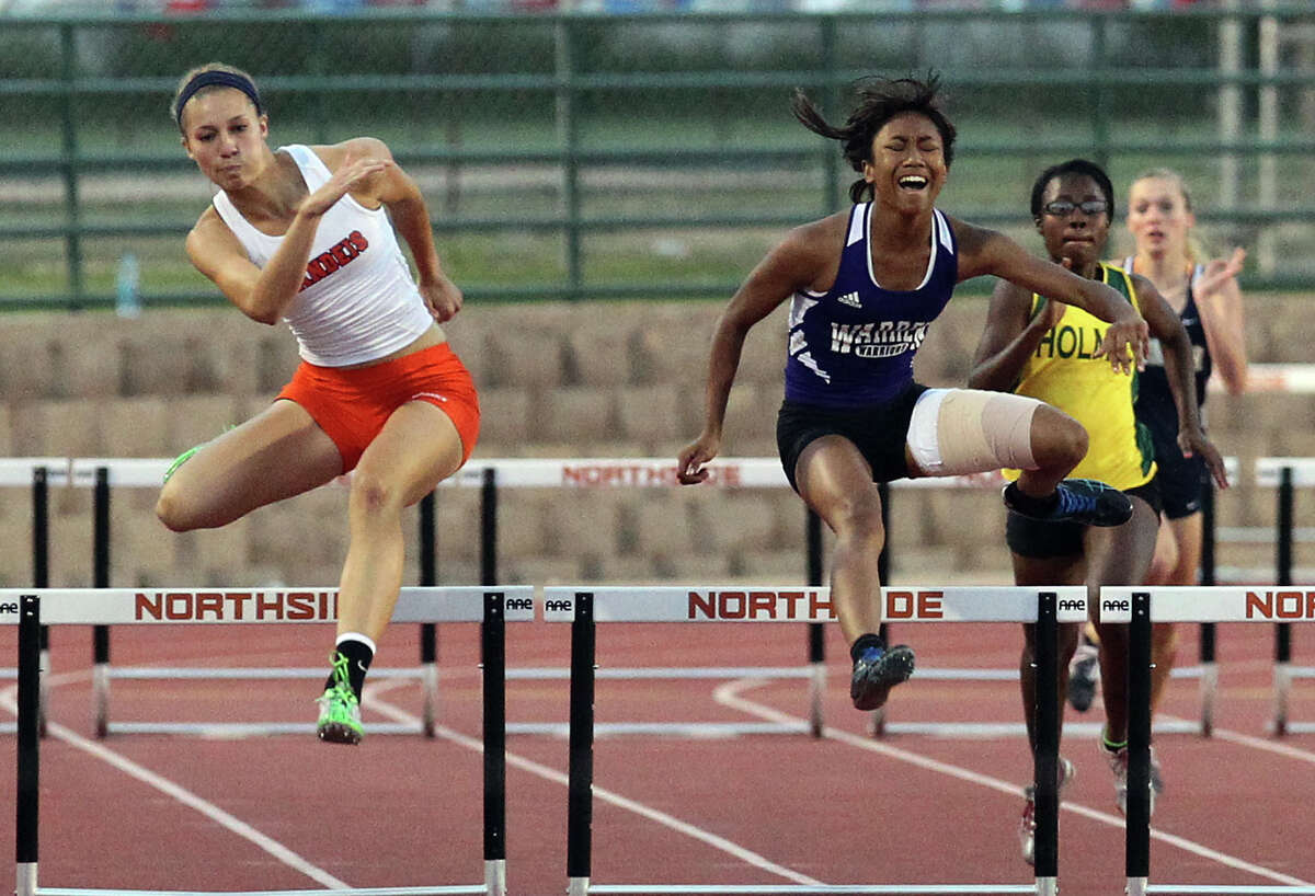 Brandeis' Kyndall Snider (left) takes first place from Warren's Jerica Love in the 300-meter hurdles at the District 27-5A track meet at Gustafson Stadium on Friday, Apr. 13, 2012. Kin Man Hui/Express-News.