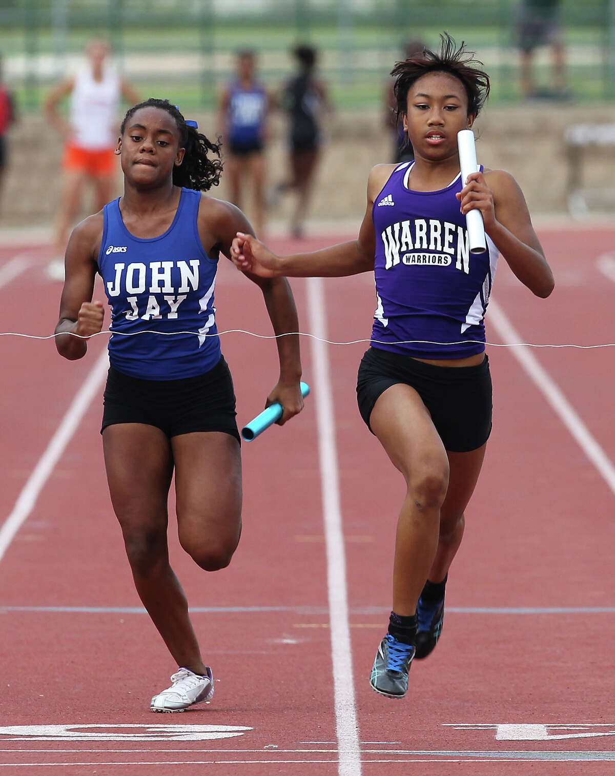 Warren's Jerica Love (right) crosses first to the finish line as the anchor runner in the 400-meter relays at the District 27-5A track meet at Gustafson Stadium on Friday, Apr. 13, 2012. Kin Man Hui/Express-News.