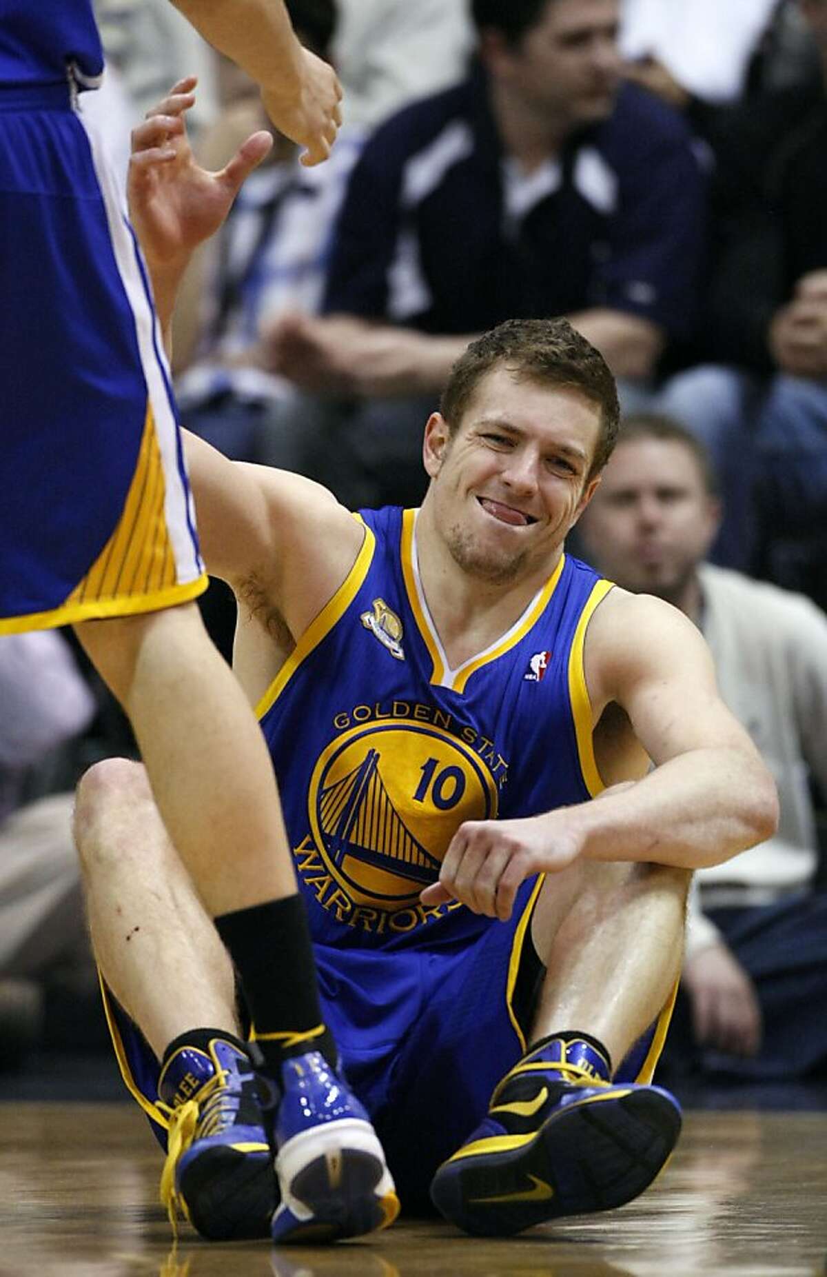 Golden State Warriors power forward David Lee (10) reaches for help up off the court floor after falling during the second half of an NBA basketball game against the Utah Jazz, Friday, April 6, 2012, in Salt Lake City.