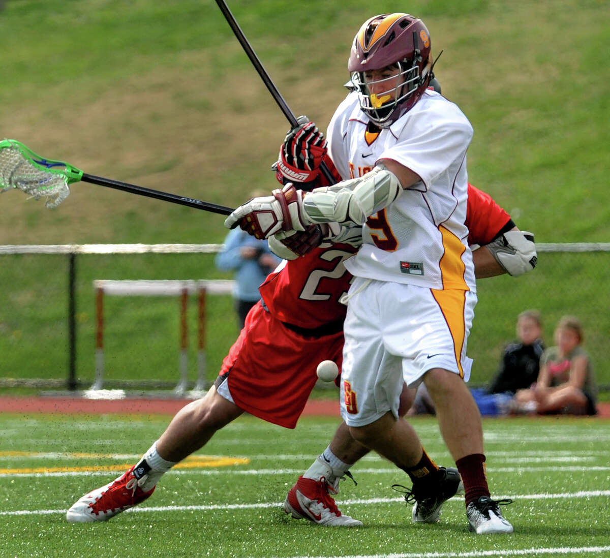 St. Joe's Christian Keator looses the ball as he is shoved from behind by New Canaan's #23 Griffin White, during boys lacrosse action in Trumbull, Conn. on Saturday April 14, 2012.