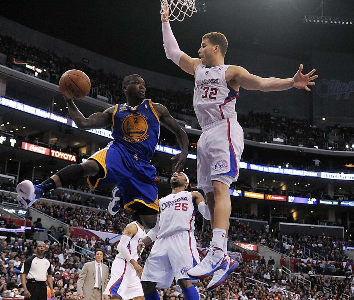 Golden State Warriors guard Nate Robinson, left, passes around Los Angeles Clippers forward Blake Griffin (32) during the second half of an NBA basketball game in Los Angeles, Saturday, April 14, 2012.