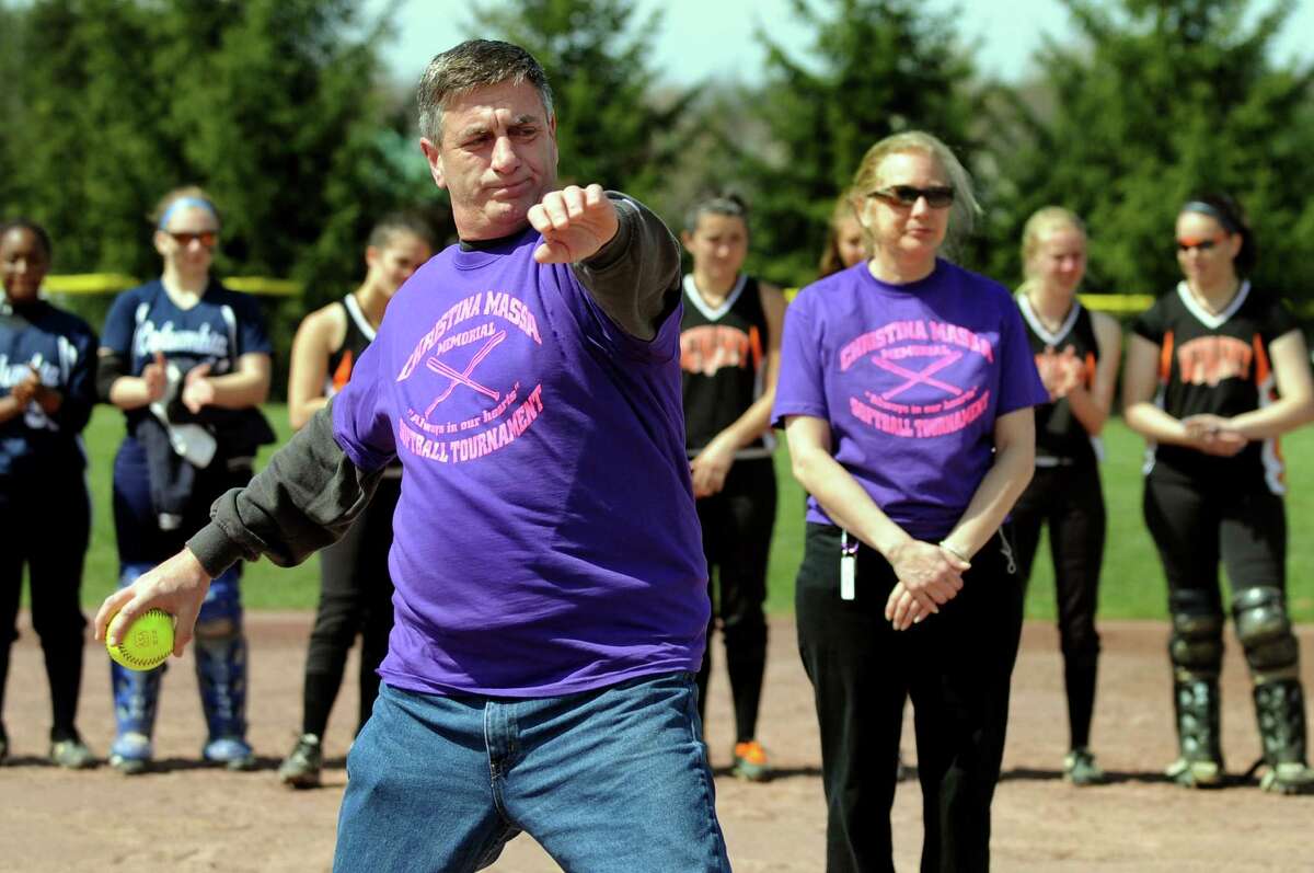 Frank Massa of Clifton Park, left, throws the ceremonial first pitch during the Christina Massa Memorial Softball Tournament on Saturday, April 14, 2012, at Clifton Park Commons in Clifton Park, N.Y. At right is his wife, Debbie. Their daughter, Christina, was a star Shenendehowa player who died in a car accident in May 2002 at the age of 18. The event raises money for scholarships given to current Shen athletes. (Cindy Schultz / Times Union)