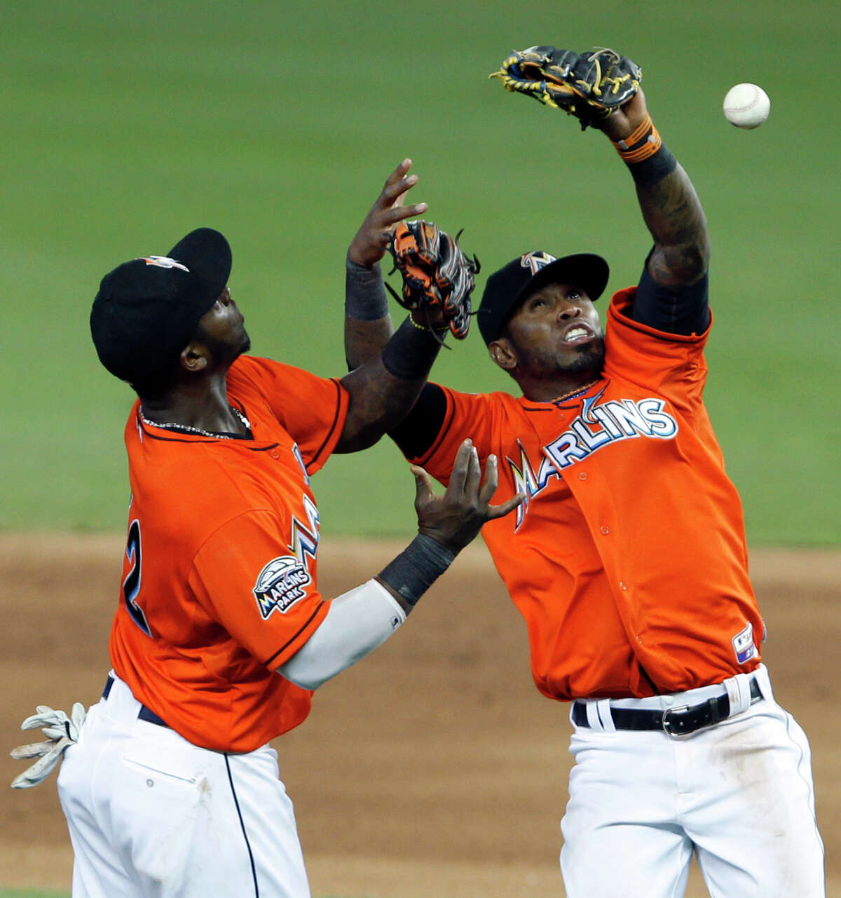 Miami Marlins third baseman Hanley Ramirez, left, and shortstop Jose Reyes bobble a ball hit by Houston Astros' Jordan Schafer during the inning 11th of a baseball game on Sunday, April 15, 2012, in Miami. The Marlins defeated the Astros 5-4 in 11 innings. (AP Photo/Wilfredo Lee)