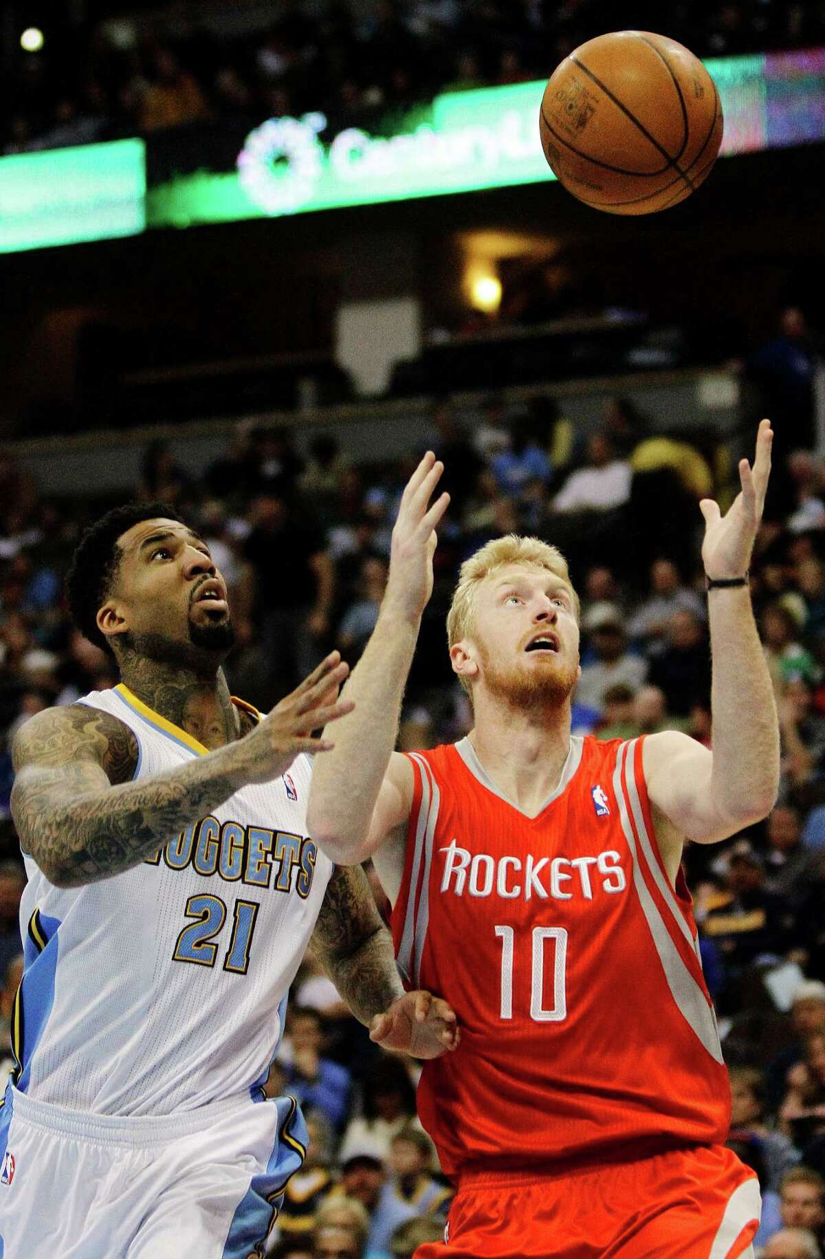 Houston Rockets small forward Chase Budinger (10) grabs a loose ball away from Denver Nuggets small forward Wilson Chandler (21) during the first quarter of an NBA basketball game Sunday, April 15, 2012, in Denver. (AP Photo/Barry Gutierrez)