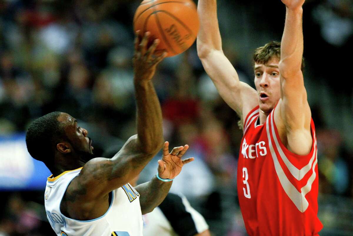 Denver Nuggets point guard Ty Lawson (3) passes the ball past Houston Rockets point guard Goran Dragic (3) while falling out of bounds during the second quarter of an NBA basketball game Sunday, April 15, 2012 in Denver. (AP Photo/Barry Gutierrez)