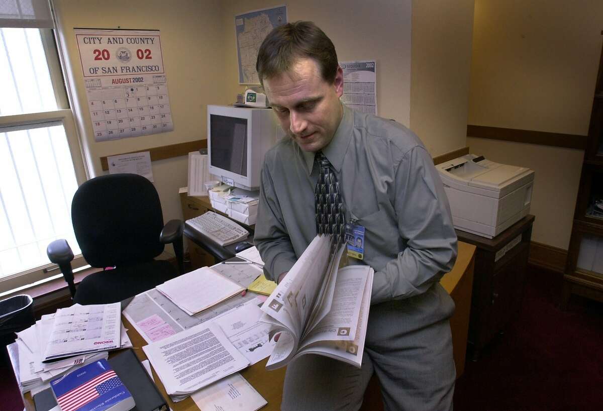 San Francisco voters can now opt out of receiving the paper copy of the Voter Information Pamphlet in the mail. VOTE-C-14AUG02-MN-PG John Arntz, acting dir. at Dept of elections in SF, thumbs thru a voter information pamphlet from the year 2000 which is over 200 pages long. He is concerned about the one coming out soon which will be over 300 pages and cost alot if mailed. San Francisco Chronicle PHOTO BY PENNI GLADSTONE --- Sent 04/15/12 18:57:09 as sfinsider16_PH with caption: