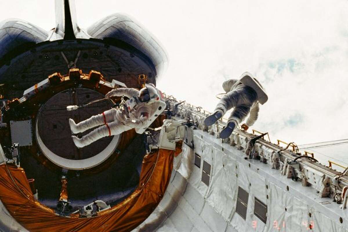 Astronauts Story Musgrave, left, and Don Peterson float in the cargo bay of the Earth-orbiting space shuttle Challenger during their April 7, 1983, spacewalk on the STS-6 mission. It was the shuttle program's first mission with a spacewalk. (NASA / NASA)