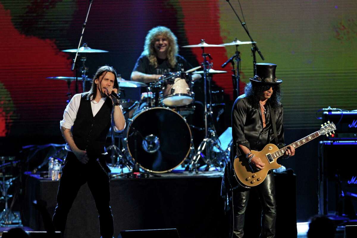 Guns N' Roses' Slash, right, and Steven Adler on drums, perform with singer Myles Kennedy, left, after induction into the Rock and Roll Hall of Fame Sunday, April 15, 2012, in Cleveland. (AP Photo/Tony Dejak)