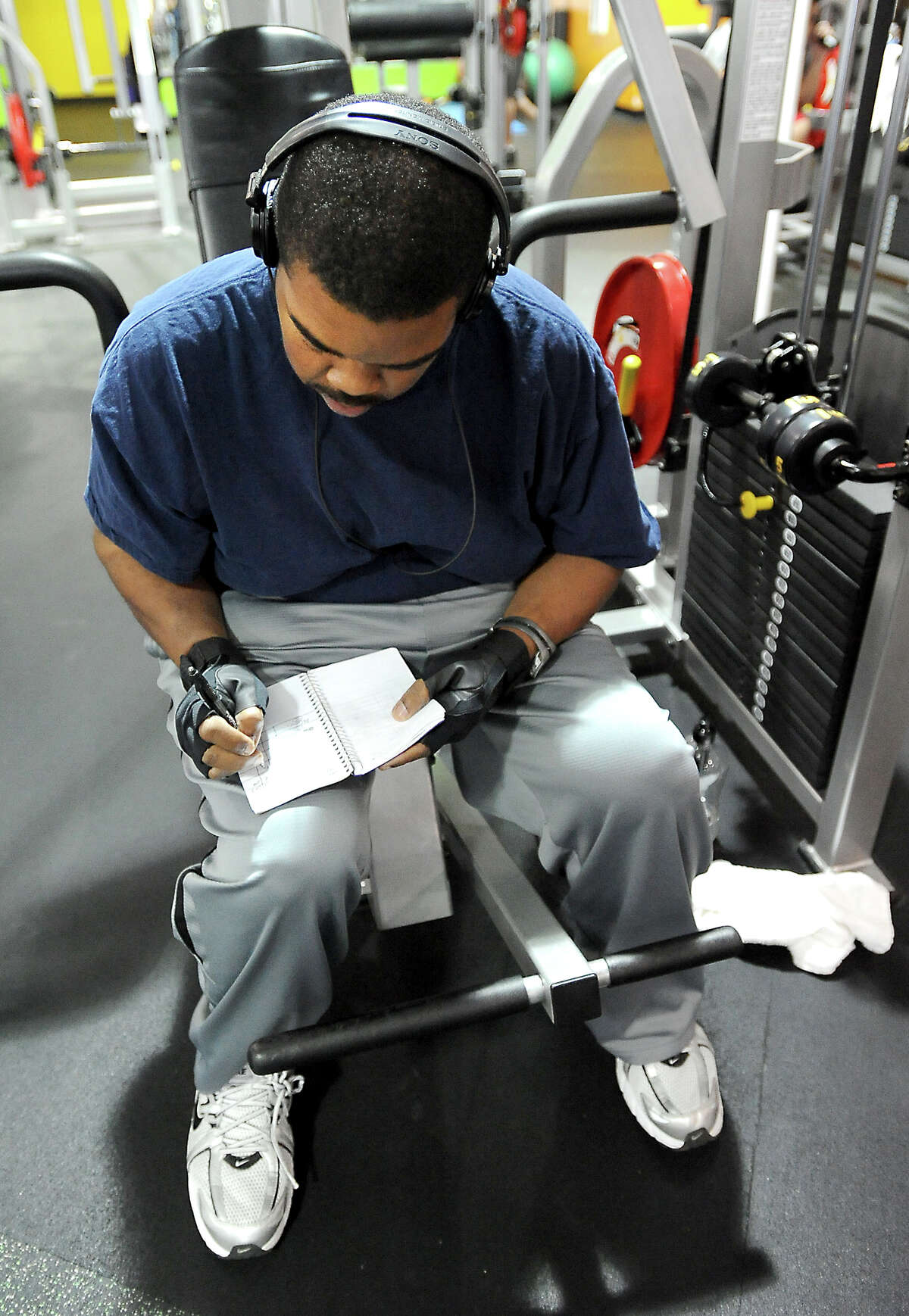 Willie Gillis III takes notes about his works outs at Exygon Health and Fitness Club in Beaumont in Beaumont, Thursday, April 12, 2012. Gillis has lost 230 pounds through diet and exercise. Tammy McKinley/The Enterprise