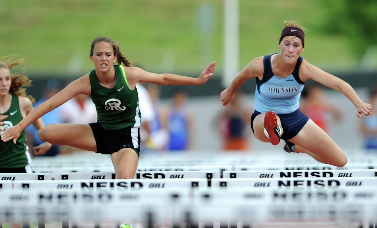 Reagan’s Chloe Young (left) and Johnson’s Kassie Freitag (right) clear hurdles during the varsity girls’ 100-meter hurdles of the District 26-5A track meet. Young finished in first place while Freitag finished in third, both advancing to the Region IV meet.