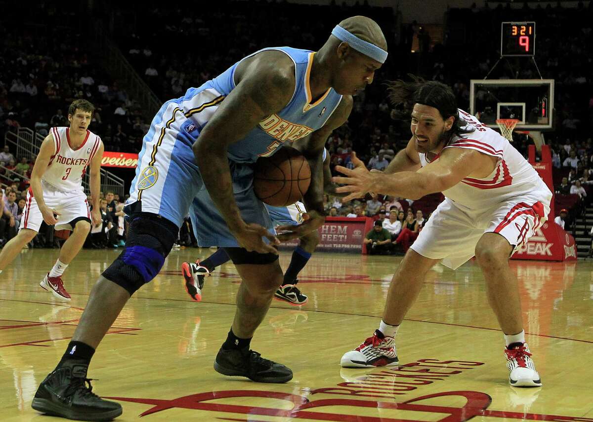 Denver Nuggets power forward Al Harrington, left, steals the balls from Houston Rockets power forward Luis Scola, right, during the first half of a basketball game at the Toyota Center Monday, April 16, 2012, in Houston. The Nuggets won 105-102.