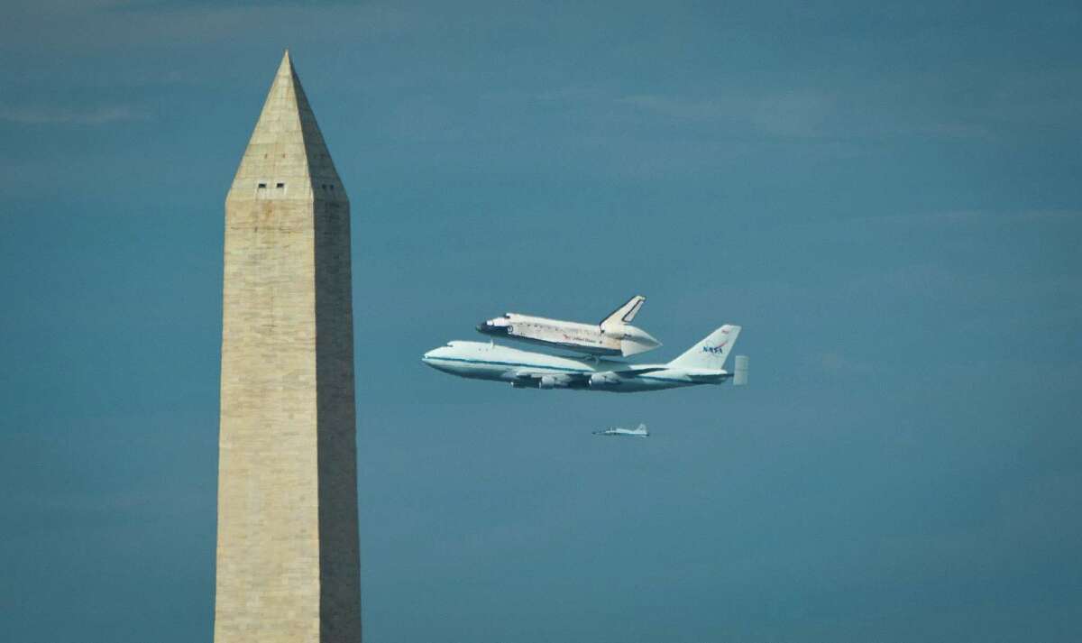 US space shuttle Discovery sitting atop NASA's 747 shuttle carrier aircraft flies by the Washington Monument. AFP PHOTO/ MLADEN ANTONOV