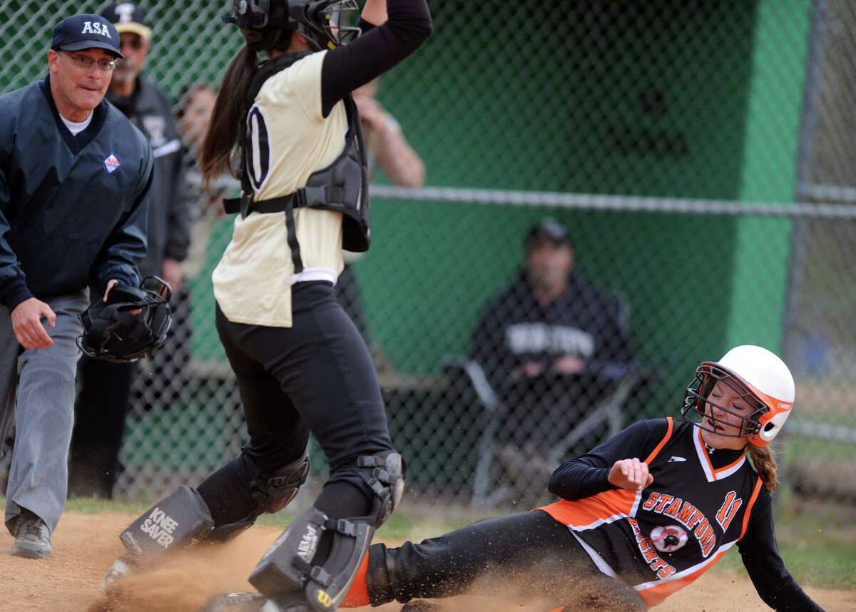 Stamford's Claire Kaptinski scores a run as Trumbull catcher Erica Quinones waits for the ball during their softball game Wednesday, April 18, 2012 at Trumbull High School.