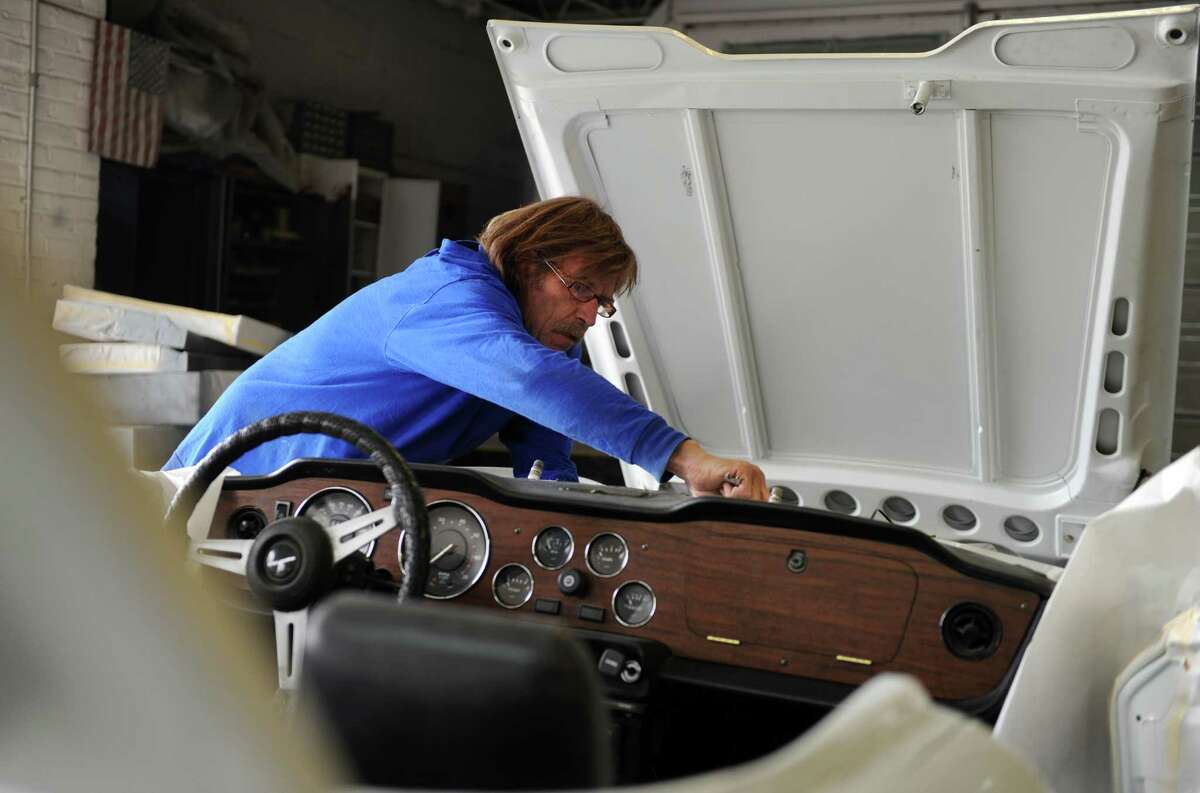 Bill Wakeman works under the hoold of a 1975 Triumph at Ash Creek Classic Cars in Bridgeport Wednesday, April 18, 2012.