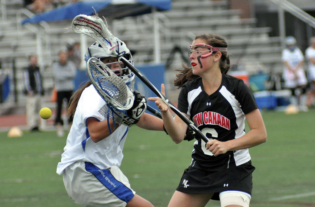 New Canaan's Beatrix Eppler (6) checks Darien's goalie Caylee Waters (1) knocking the ball loose during the girls lacrosse game at Darien High School on Wednesday, Apr. 18, 2012.