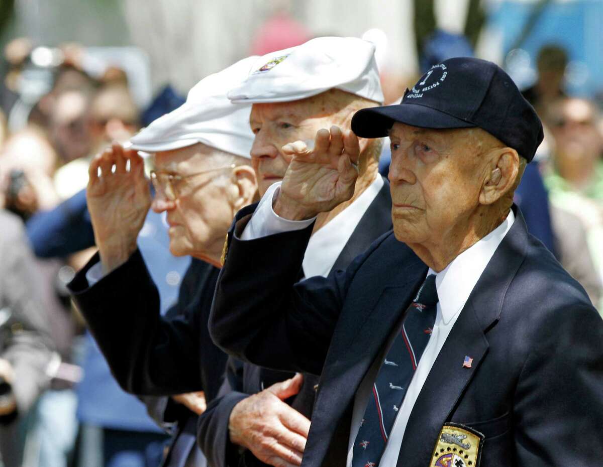 Surviving Doolittle Raider Richard E. Cole, right, salutes during the singing of the national anthem at a memorial service for the the 70th anniversary of the Doolittle raid on Tokyo at the National Museum of the United States Air Force in Dayton, Ohio Wednesday, April 18, 2012. Four survivors took part in the ceremonies including David Thatcher, second from right, Thomas C. Griffin, left, nd Edward E. Saylor, not seen.