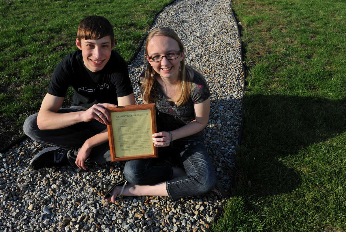 Ben Huebner and his freind Becky Schwarz pose at Becky's home in Ansonia, Conn. on Thursday April 19, 2012. Ben asked Becky to the prom using the rules list they are holding. He had rule #3 printed asking her to the prom as a surprise in their high school youth group.
