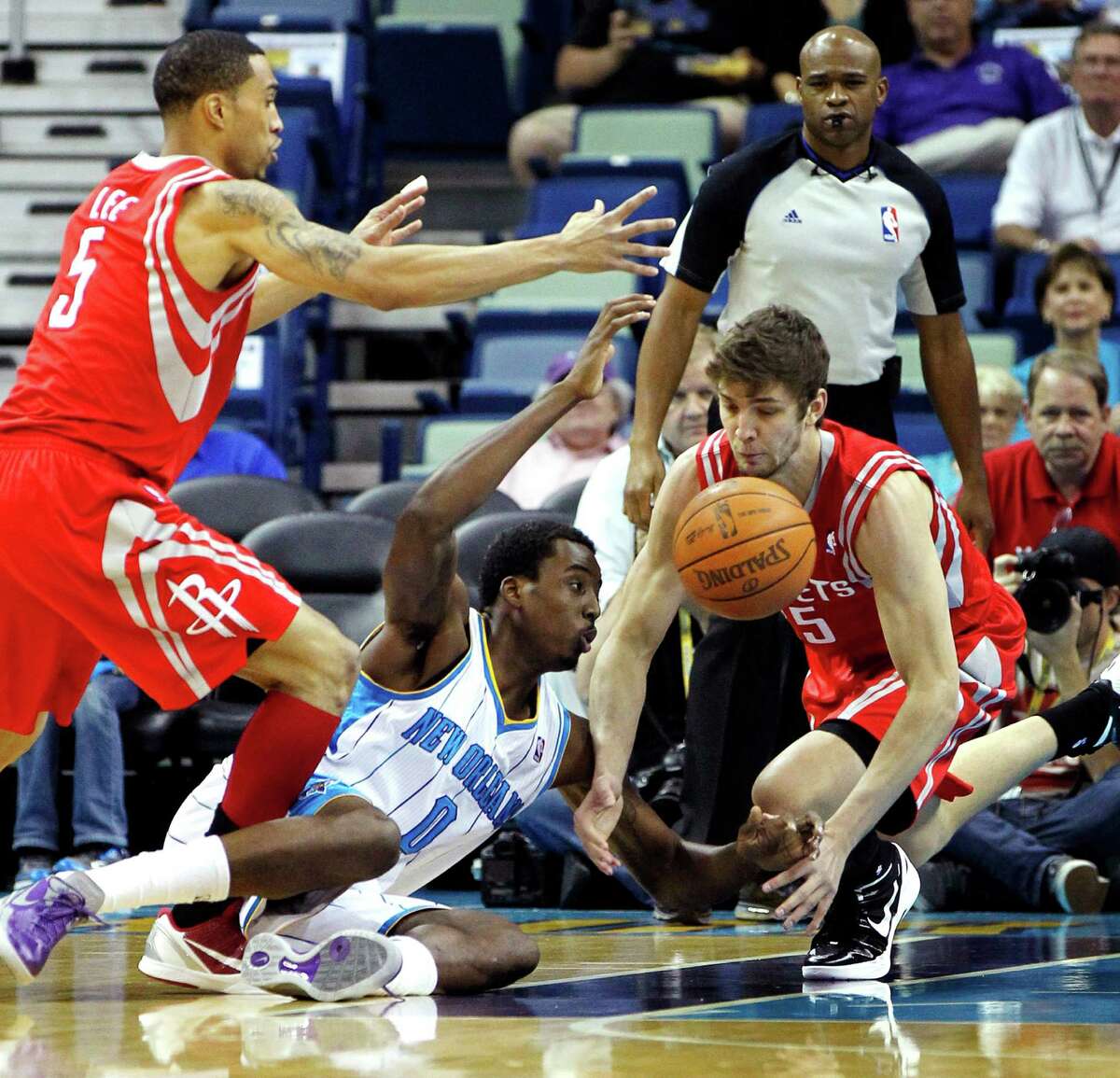 New Orleans Hornets small forward Al-Farouq Aminu (0) battles for a loose ball with Houston Rockets shooting guard Courtney Lee (5) and forward Chandler Parsons, right, in the first half of an NBA basketball game in New Orleans, Thursday, April 19, 2012. (AP Photo/Gerald Herbert)