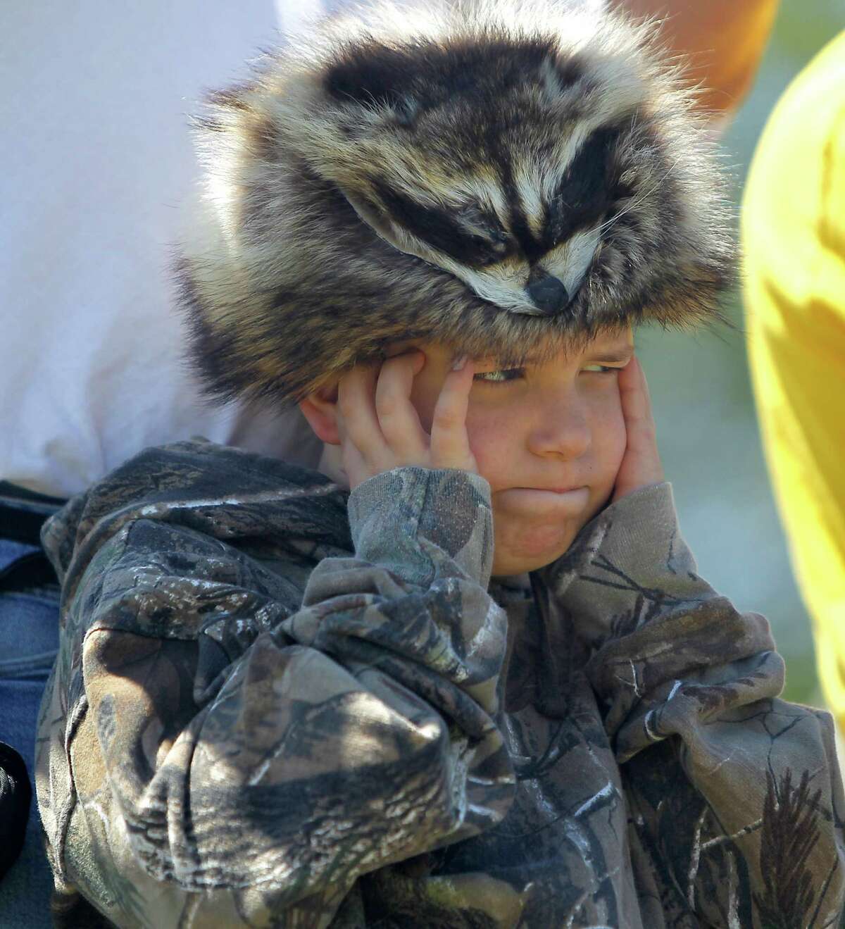 Wade Moore, 7, of Deer Park, covers his ears wearing a coon-skin cap as a cannon is fired during festivities commemorating the 176th anniversary of the battle of San Jacinto at the San Jacinto Battleground, Saturday, April 21, 2012, in Houston.
