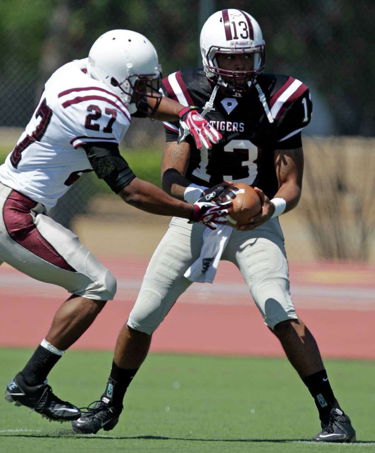 Texas Southern University Tiger's Tony Peoples, left, takes a handoff from QB Riko Small during the spring football game at TSU's Alexander Durley Stadium Saturday, April 21, 2012, in Houston.