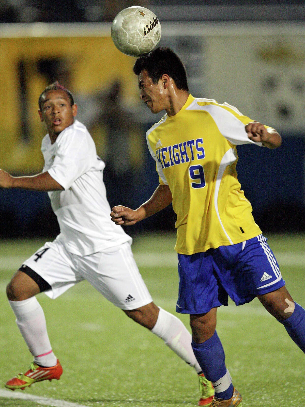 Alamo Heights' Christian Garcia heads a ball as Wichita Falls Rider's Juan Orozco looks on during first half action of the Class 4A state final game Saturday, April 21, 2012 at Birkelbach Field in Georgetown.