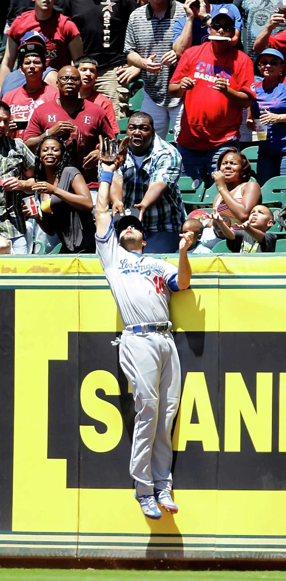 Los Angeles Dodger's Andre Ethier (16) tries in vain to catch a grand slam home run ball hit by Houston Astros center fielder Jordan Schafer (1) during the 2nd inning of an MLB baseball game at Minute Maid Park,Sunday, April 22, 2012, in Houston.