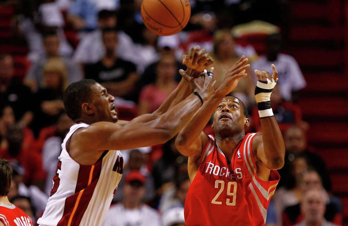 Marcus Camby #29 of the Houston Rockets and Dexter Pittman #45 of the Miami Heat fight for a loose ball during a game at American Airlines Arena on April 22, 2012 in Miami, Florida. NOTE TO USER: User expressly acknowledges and agrees that, by downloading and/or using this Photograph, User is consenting to the terms and conditions of the Getty Images License Agreement.