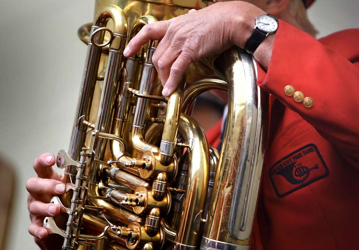 A tuba player clutches his instrument as he plays a song at Golden Gate Park in San Francisco on Sunday. The Golden Gate Band, conducted by Michael Wirgler, played it's first concert of the season at Golden Gate Park on Sunday marking their 130th year.