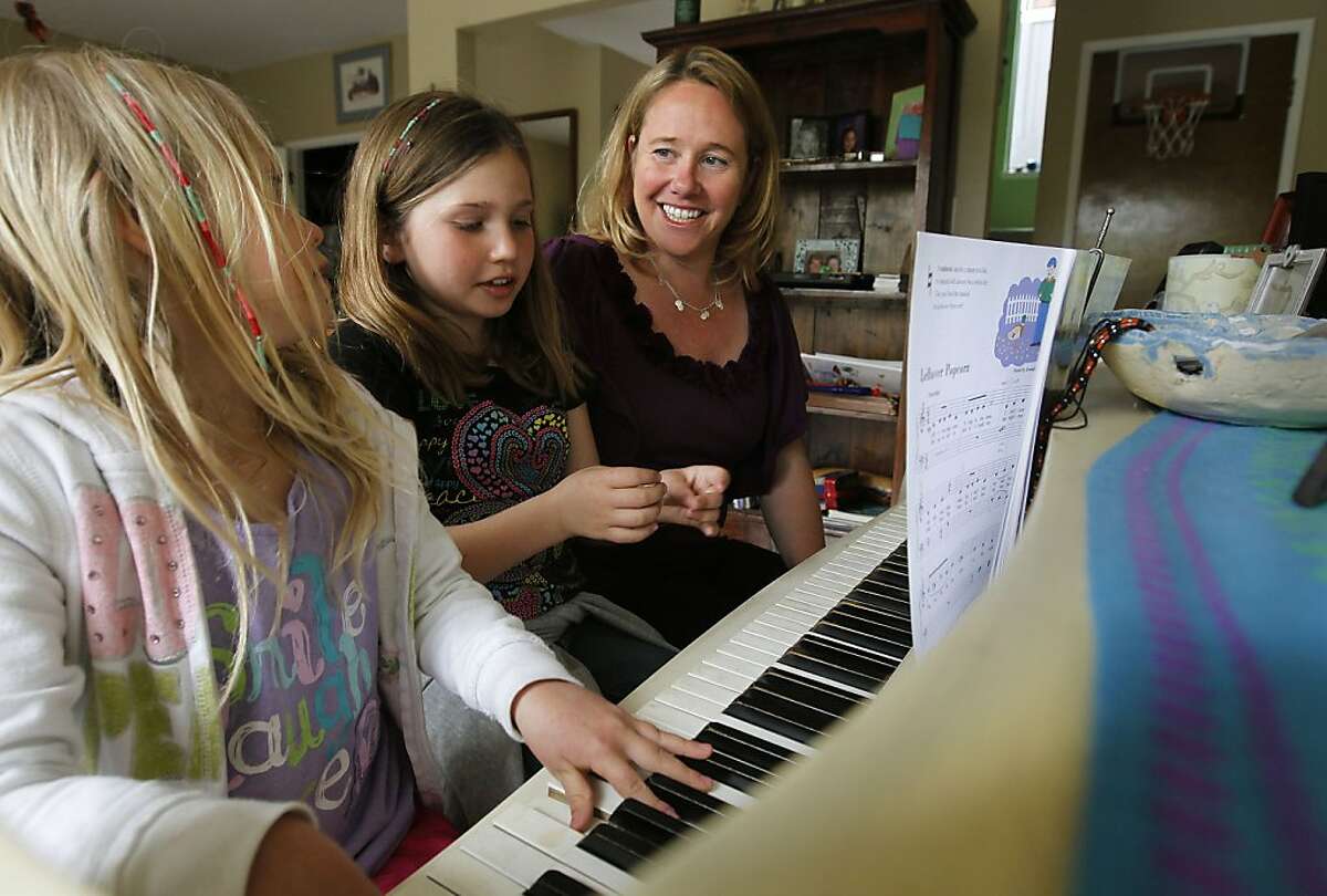 Raychel Kubby Adler with her two daughters, Ruby, 6 and Marley, 9, play piano at their Davis, Ca. home, on Wednesday April 18, 2012. A year and a half after Raychel Kubby Adler discovered she carried a genetic mutation that gave her an 87 percent lifetime chance of developing breast cancer, she opted to have a prophylactic double mastectomy at age 36. She has a new online tool to help her weigh her options. Using the interactive tool, which was developed by Stanford University School of Medicine researchers, Kubby Adler learned her risk of developing ovarian cancer may remain relatively low whether she has the surgery now at age 40 or waits until sheís 45.
