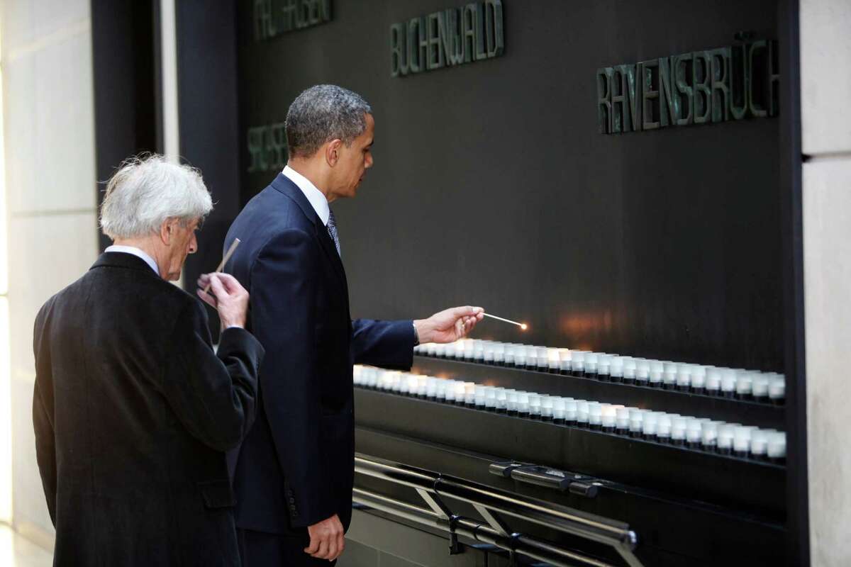 U.S. President Barack Obama (R) and Elie Wiesel light candles in the Hall of Remembrance at the Holocaust Museum April 23, 2012 in Washington, DC. Obama reportedly announced a new sanctions March 23, on Iran and Syria for entities and people using technology to target citizens.