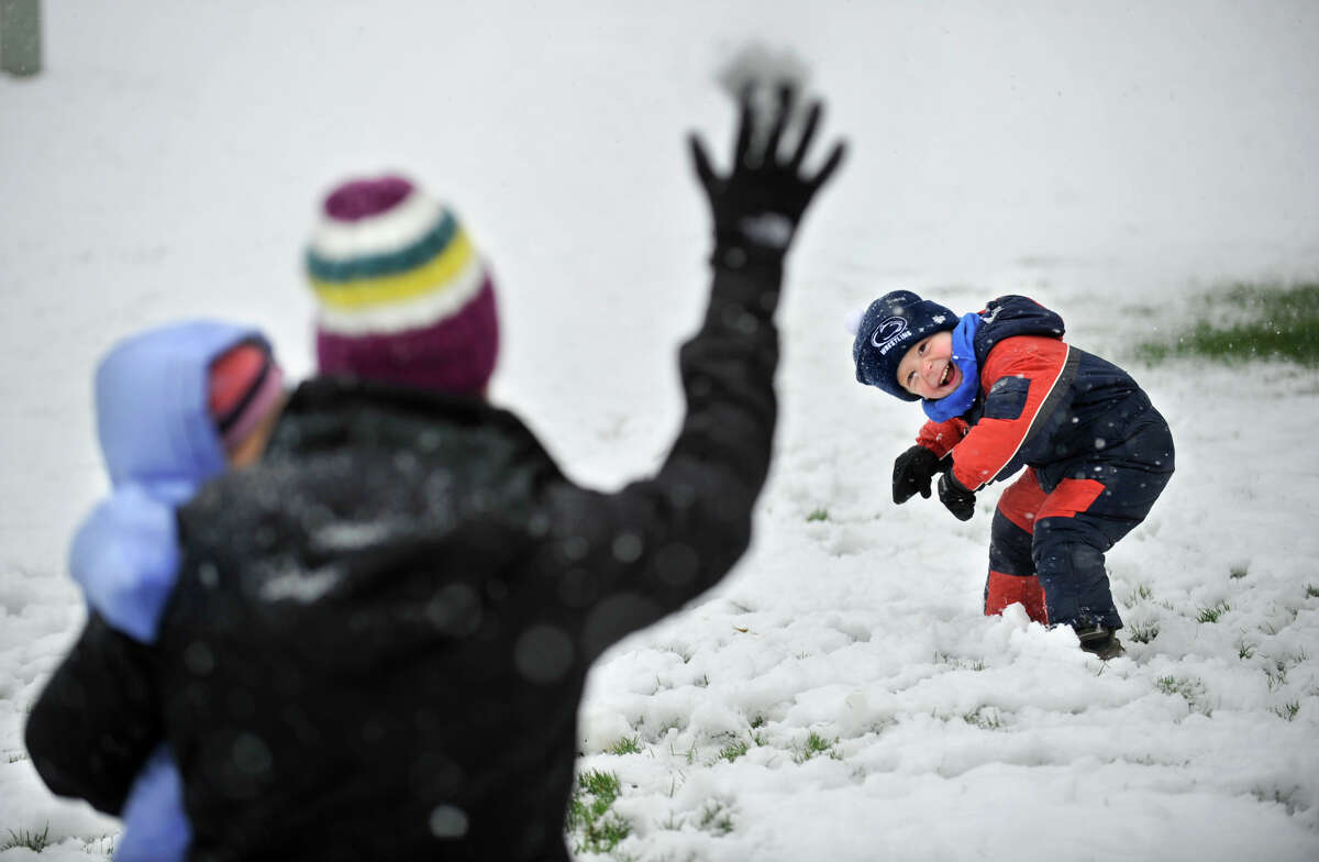 Evan Dreibelbis, 3, tries to avoid a snowball during a snowball fight in fresh snow in their front yard with his mother Dana Dreibelbis and sister Elle Monday, April 23, 2012 in Pine Grove Mills, Pa. A spring nor'easter packing soaking rain and high winds churned up the Northeast Monday morning, unleashing a burst of winter and up to a foot of snow in higher elevations inland, closing some schools and sparking concerns of power outages(AP Photo/Centre Daily Times, Nabil K. Mark)