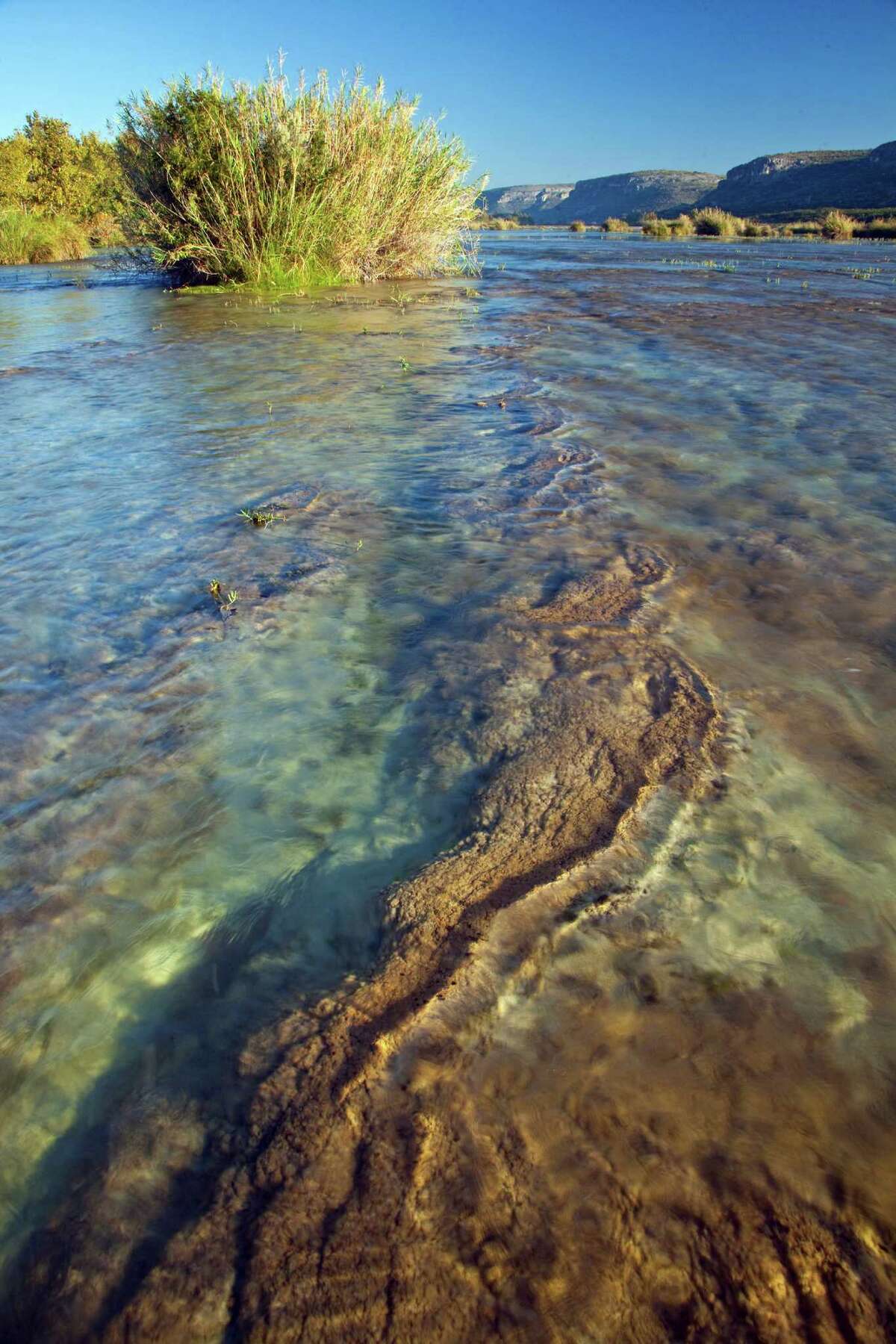 In this Oct. 2009 photo provided by the Texas Parks and Wildlife Dept., the Devils River is shown flowing through a canyon on the Devils River Ranch near Del Rio, Texas. The Texas Parks and Wildlife Department wants to give a Dallas businessman a remote, 20,000-acre parcel of land along the Devils River plus $8 million in exchange for his 17,000-acre ranch, a proposal that has pit local landowners against one another and that is opposed by environmental groups. (AP Photo/Laurence Parent)