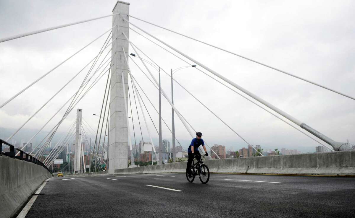 A lone bicyclist rides on a bridge, free of traffic, in Medellin, Colombia, Monday, April 23, 2012. Many residents of Medellin walked, biked, or took buses and taxis to their destinations honoring the car-free day. It was the fifth straight year for the Day Without Cars campaign in which cars are banned for a day to promote alternative transportation as a way to reduce smog.