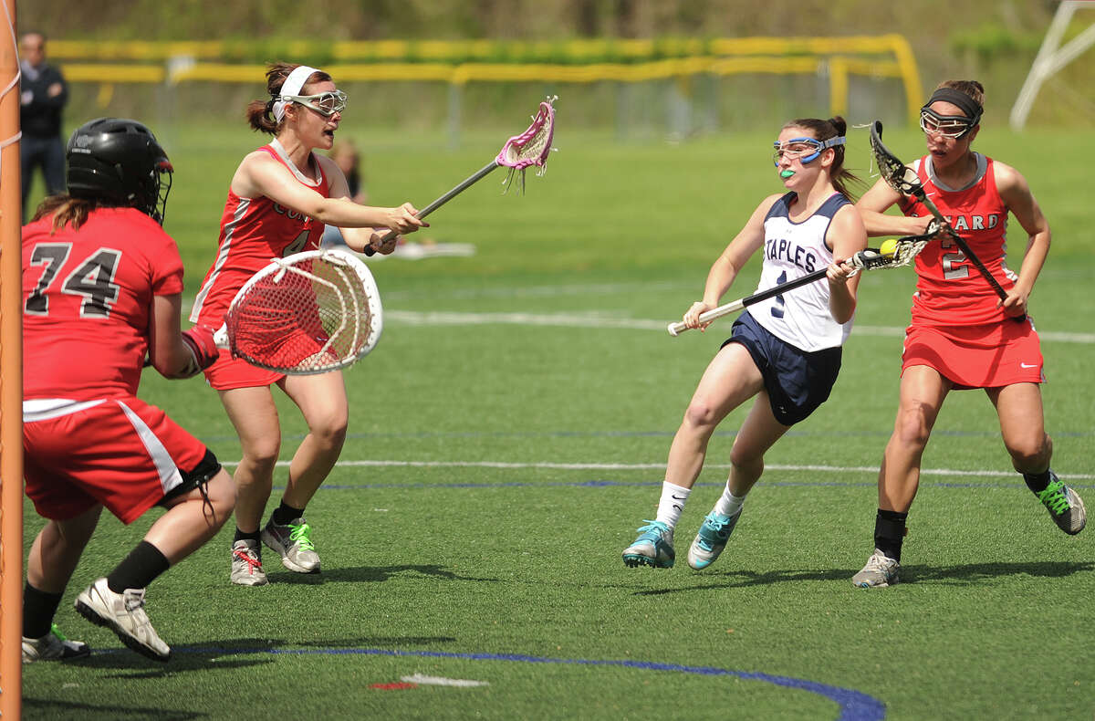 Staples' Paige Murray, white uniform, controls the ball against Conard last Wednesday. Murray had six goals Friday in a 15-12 home win over Trumbull.