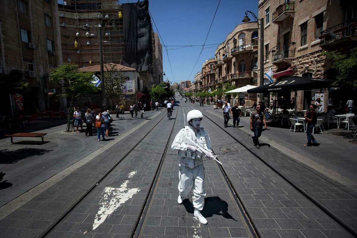 Artist Matan Goldberg, walks in Jerusalem as a part of performance titled "The White Soldier" , Wednesday, April 25, 2012. On Wednesday Israel marks Memorial Day in remembrance of the nation's fallen soldiers since 1948. Artists symbolically patrolled along the 1967 'Green Line' which separated Israel from the Jordanian-controlled East Jerusalem which was captured by Israel in the 1967 Six-Day-War.