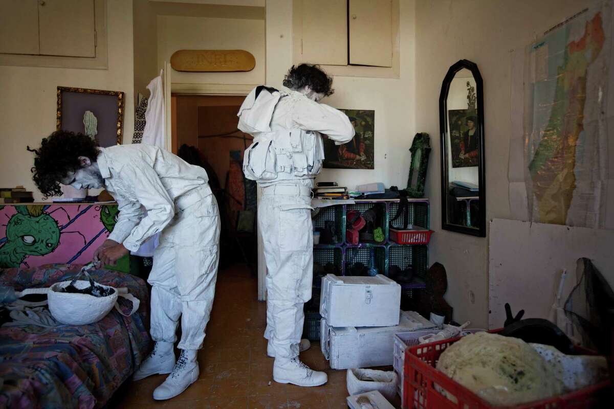 Artists Yuda Braun, left, and Matan Goldberg dress up in painted army uniforms before they go out to the streets in Jerusalem as a part of performance entitled "The White Soldier" , Wednesday, April 25, 2012.