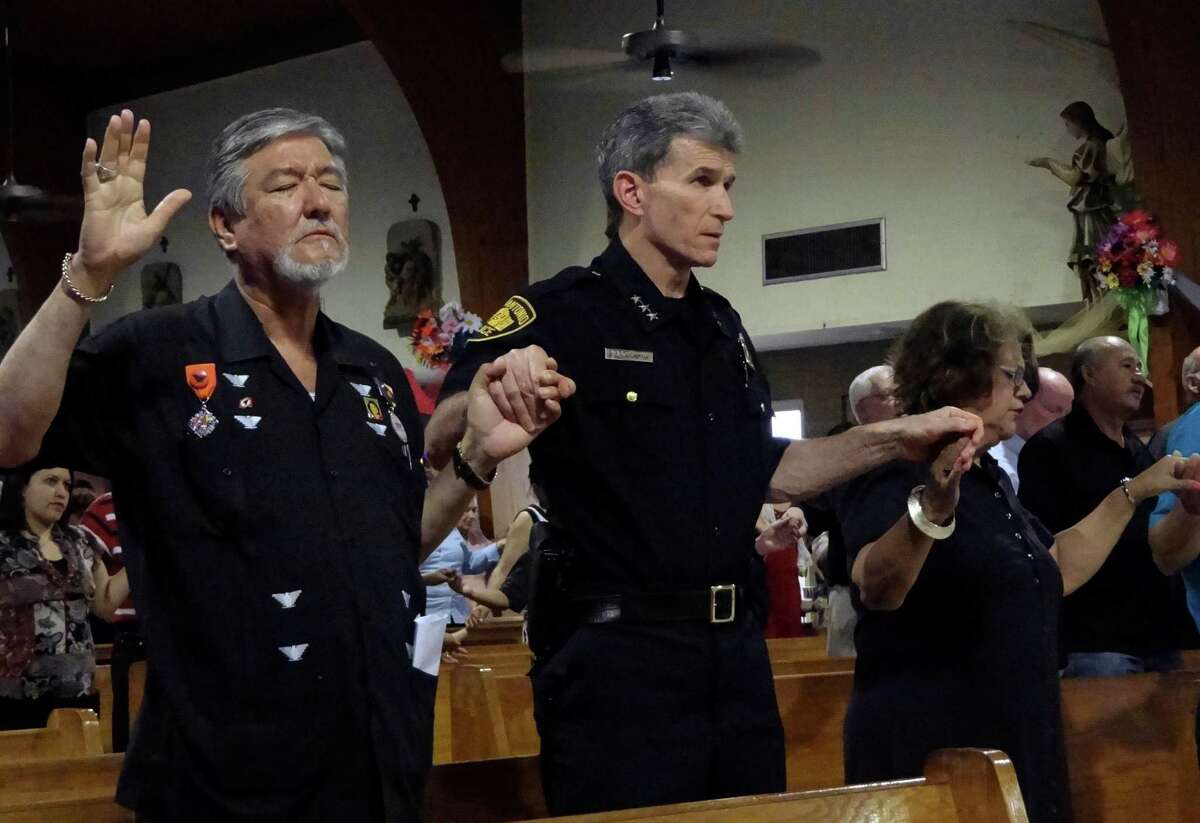 San Antonio Police Chief William McManus, middle, participates in a "Mass for Justice" at Sacred Heart Catholic Church on Wednesday, April 25, 2012. Jaime P. Martinez, left, is the founder of the Cesar E. Chavez Foundation. The service was said to address the Arizona anti-immigration law, S.B. 1070, which was heard by the United States Supreme Court. McManus said that the San Antonio police do not care about a person's immigration status. Billy Calzada / San Antonio Express-News
