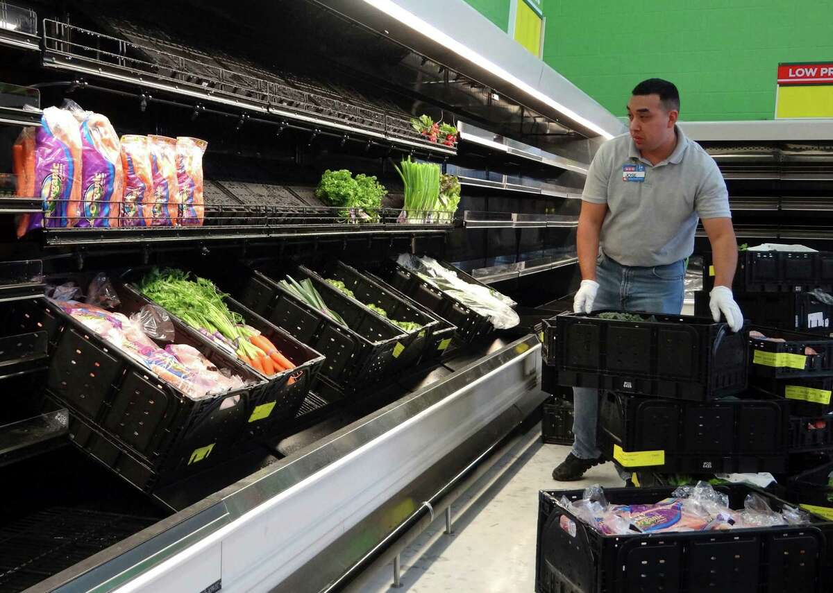 Jose Castillo stocks produce on shelves in the new H-E-B Plus at Loop 1604 and Bandera Road.