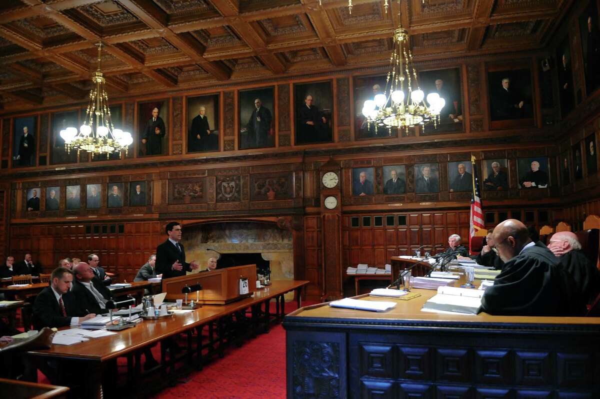 Attorney Eric Hecker, representing petitioners from the Democratic Senate minority, center, makes his case to the New York State Court of Appeals, while his opponents Michael Carvin, representing Senate Majority Leader Dean Skelos, seated second from left, and John Gore, left, listen during a petition to challenge the constitutional validity of legislation reapportioning State Senate districts based on the 2010 federal census, which increases the size of the Senate from 62 seats to 63, on Thursday April 26, 2012 in Albany, NY. (Philip Kamrass / Times Union )