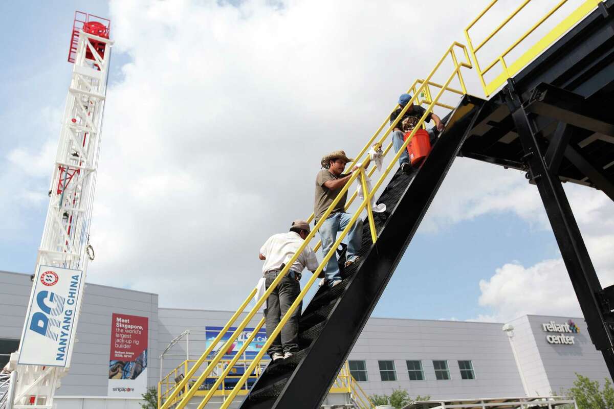 Elvis Gonzalez wipes the stair rail of the Loadcraft Industries Platform as companies set up in preparation for the Offshore Technology Conference at Reliant Center on Friday, April 27, 2012, in Houston.