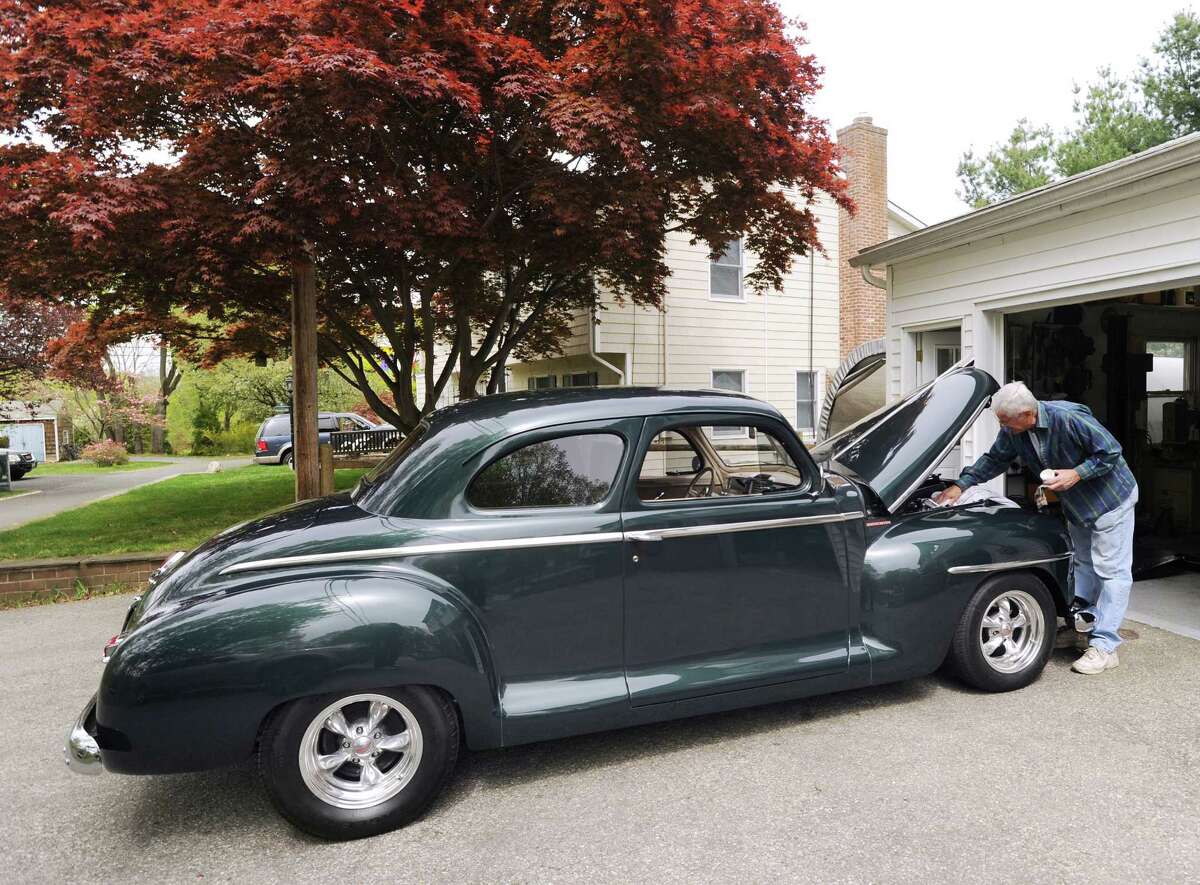 Frank Yantorno works on his 1947 Plymouth Coupe at his Neighborly Way home in Riverside, Wednesday, April 18, 2012. Under a controversial bill that is making the rounds in the General Assembly, automobiles such as Yantorno's with Early American license plates would be taxed at a higher rate.