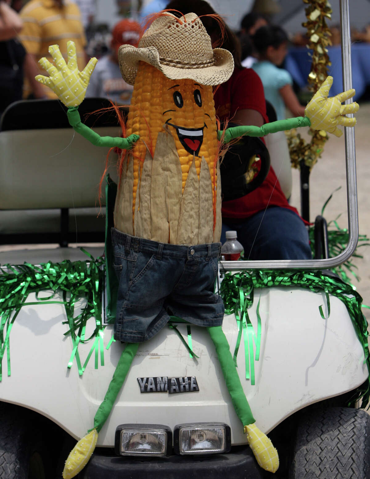 A worker at the Helotes Cornyval drives a golf cart with a large corn character mounted on the front on Sunday May 4, 2008. JOHN DAVENPORT/jdavenport@express-news.net