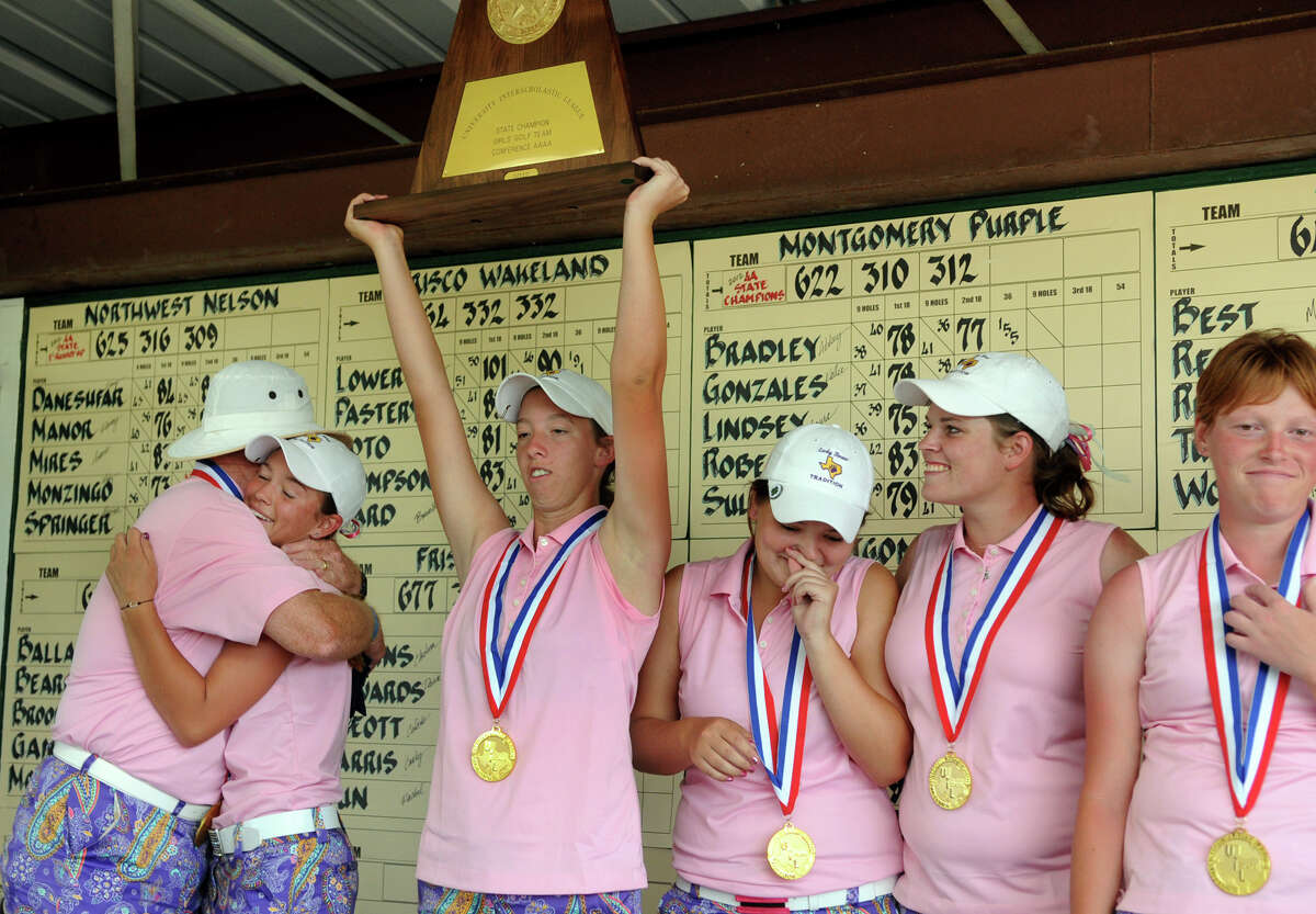 Montgomery Head Golf Coach Rusty Herridge, from left, hugs senior Abbey Bradley while teammates Kirby Sullivan, Kallie Gonzales, Laura Lindsey, and Paige Roberts show their excitement during the trophy presentation at the Class 4A state golf championship at Jimmy Clay Golf Course in Austin on Tuesday.