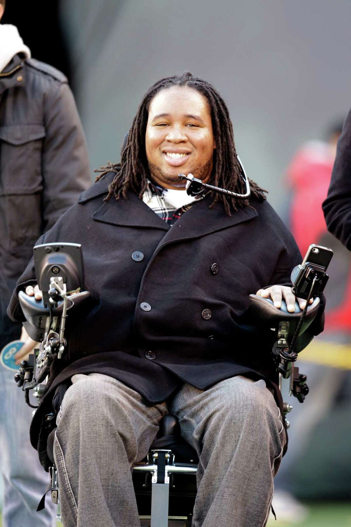 FILE - This Dec. 24, 2011 file photo shows paralyzed former Rutger's football player Eric LeGrand smiling on the sidelines before an NFL football game between the New York Giants and the New York Jets, in East Rutherford, N.J. LeGrand has been signed by the Tampa Bay Buccaneers. LeGrand broke two vertebrae and suffered a serious spinal cord injury on Oct. 16, 2010 during a kickoff return against Army. His coach at Rutgers then, Greg Schiano, now is coach of the Bucs.