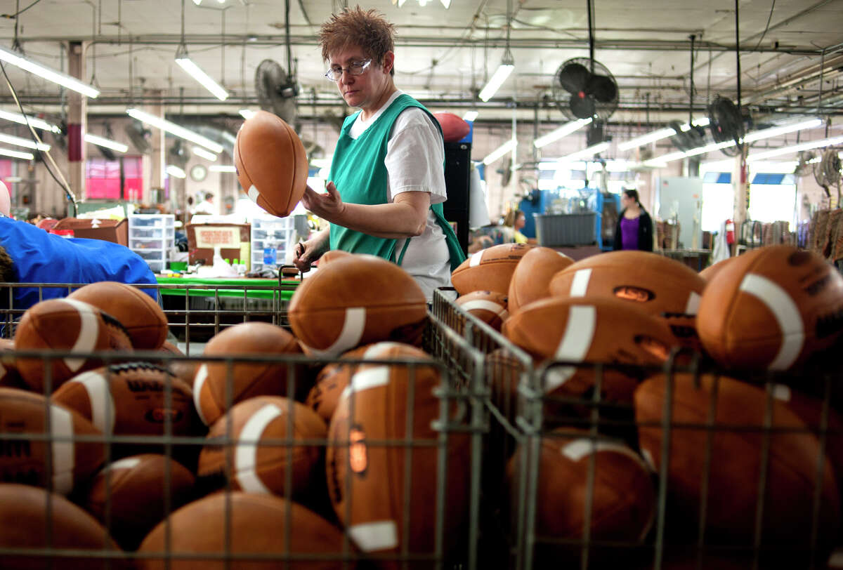 Footballs are hand inspected at the Wilson Sporting Goods Co. Wilson Football Factory in Ada, Ohio, U.S., on Wednesday, May 2, 2012. Since 1941 every NFL game ball that's appeared in Super Bowl competition has been made at the Wilson Football Factory. Photographer: Ty Wright/Bloomberg