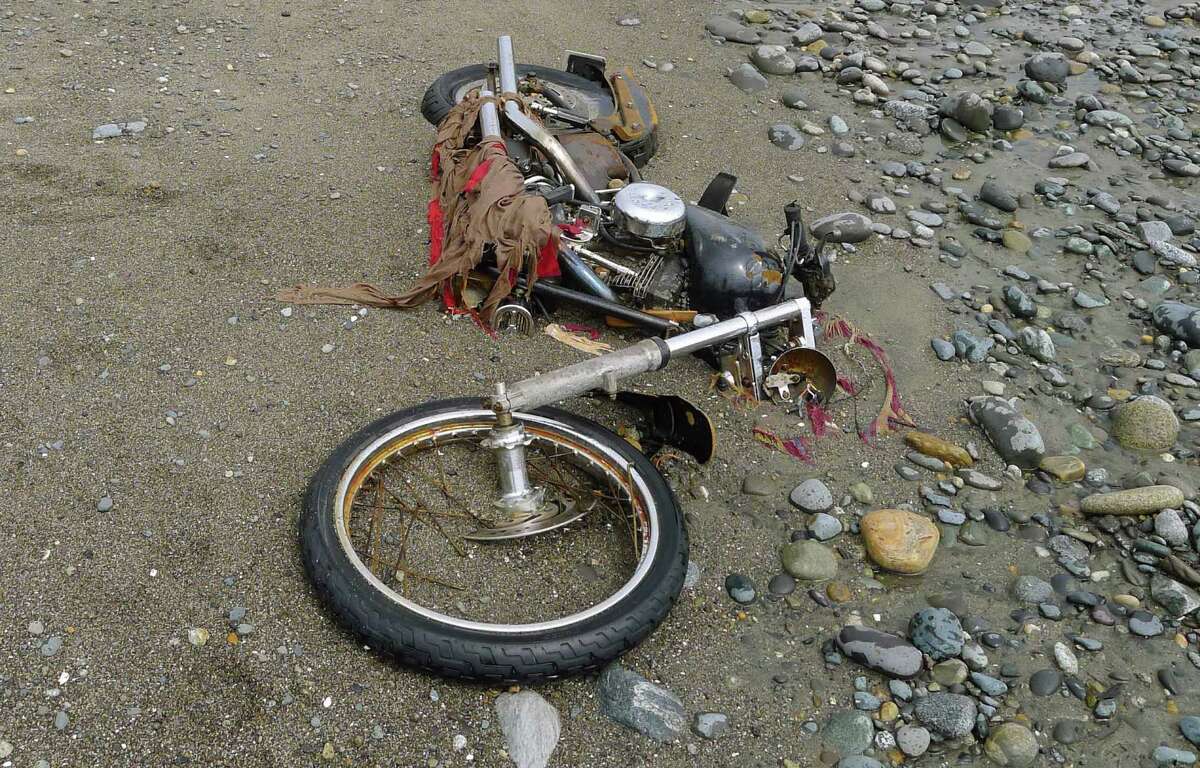 In this photo taken by Canadian Peter Mark in the end of April, 2012, and released on Wednesday, May 2, a Harley-Davidson motorbike lies on a beach in Graham Island, western Canada. Japanese media say the motorcycle lost in last year's tsunami washed up on the island about 6,400 kilometers (4,000 miles) away. The rusted bike was originally found by Mark in a large white container where its owner, Ikuo Yokoyama, had kept it. The container was later washed away, leaving the motorbike half-buried in the sand. Yokoyama, who lost three members of his family in the March 11, 2011, tsunami, was located through the license plate number, Fuji TV reported Wednesday. (AP Photo/Kyodo News, Peter Mark) JAPAN OUT, MANDATORY CREDIT, NO LICENSING IN CHINA, HONG KONG, JAPAN, SOUTH KOREA AND FRANCE