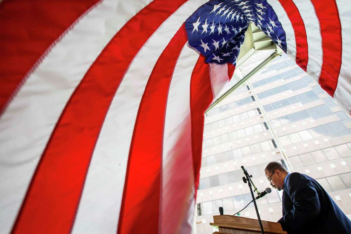 Reese Williams reads a prayer as people gather for the 61st annual observance of the National Day of Prayer outside the George Thomas "Mickey" Leland Federal Building, Thursday, May 3, 2012, in Houston.