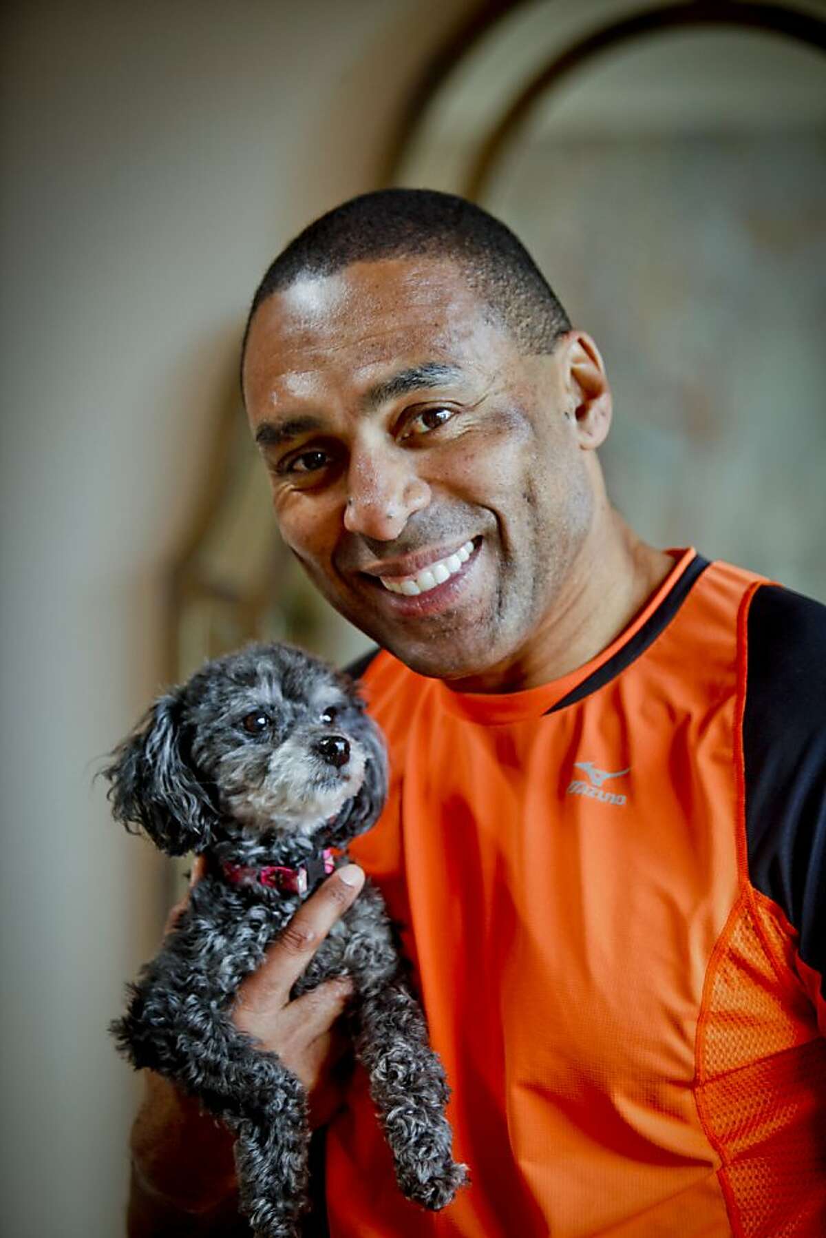 Former San Francisco 49er running back Roger Craig is seen with his dog, Coco, in his Portola Valley home on Friday, May 27, 2011.