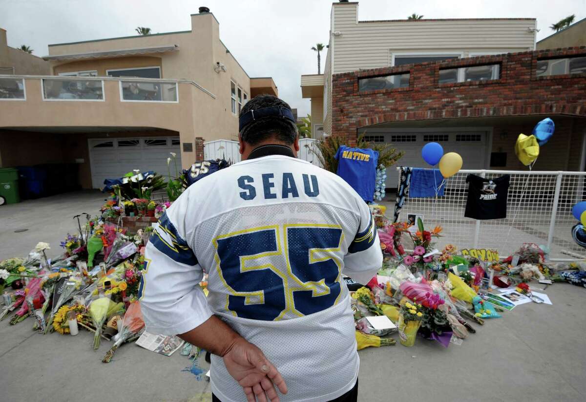 Chargers fan Jerry Lopez looks over a memorial at the home of former NFL star Junior Seau, who was found dead Wednesday.